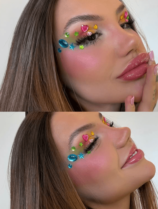 Uma imagem dividida em duas partes verticais mostrando um close do rosto de uma mulher com cabelos castanhos longos e lisos. Ela usa uma maquiagem colorida nos olhos com sombra em tons suaves, cílios postiços volumosos e pequenas pedrinhas coloridas e brilhantes (em formatos como corações, estrelas e círculos) coladas artisticamente ao redor dos olhos e pálpebras. Ela tem lábios carnudos com gloss rosa brilhante e as unhas pintadas de rosa claro.